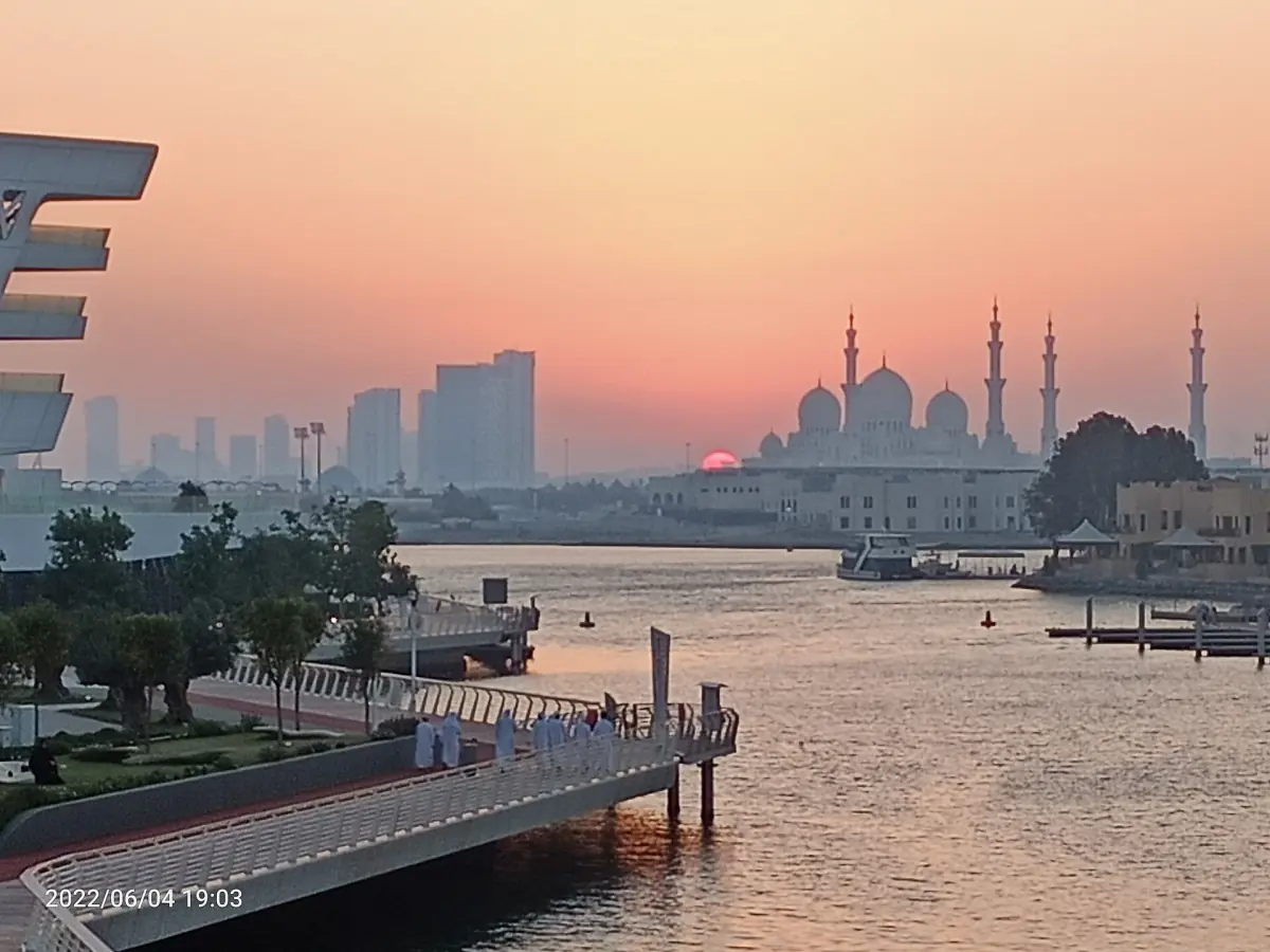 Sheikh Zayed Grand Mosque at sunset, seen across the water from Al Qana